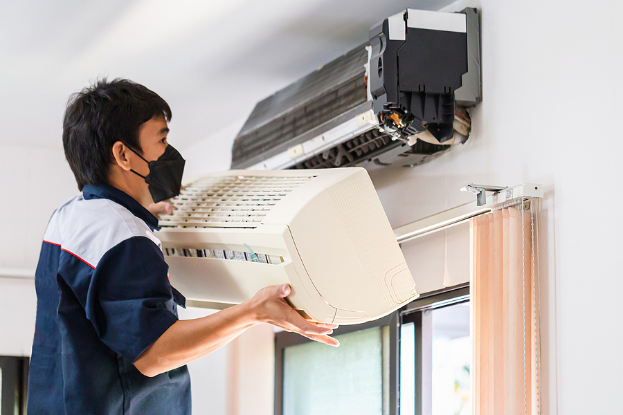 Repairman changing air conditioning filter