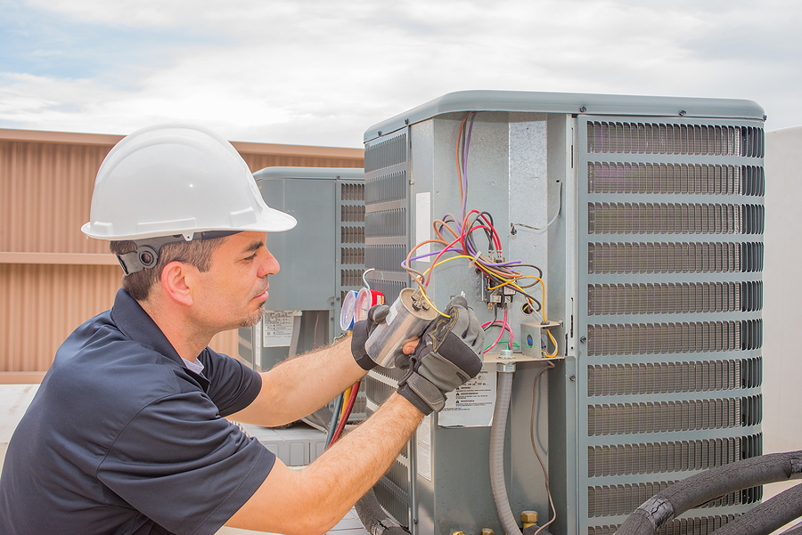 Hvac Tech checking a commercial ac unit outdoor coil