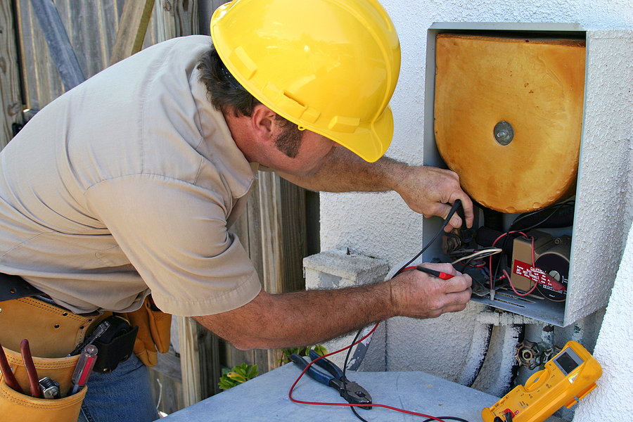 HVAC repair technician testing an ac unit in Naples, FL